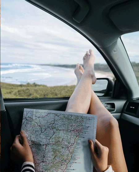 Beskrivende titel - Vises på hover Person læser kort i bilen og kigger ud over havet i USA