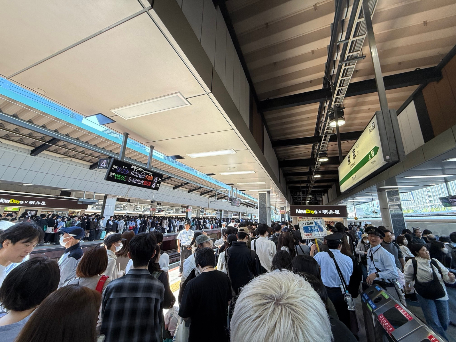 Japansk togstation i myldretid, hvor rejsende pænt venter på shinkansen