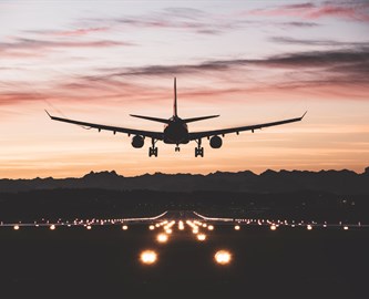 Fly tæt ved landingsbane i solnedgang.