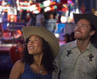 Par med cowboyhatte i tivoli under Calgary Stampede-festivalen i Canada. Foto: Colin Way, Tourism Calgary