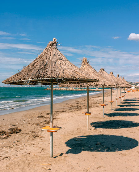 Palmeparasoller på stranden ved Golem, Albanien Palmeparasoller på stranden ved Golem, Albanien