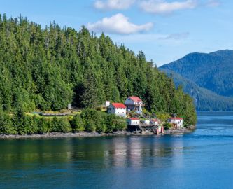 Inside Passage: Udsigt over Træer og fjord med små huse langs breden