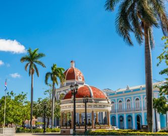 Caribiens perle, Cienfuegos på Cuba – med flot bygning, palmer og blå himmel