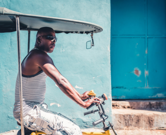 Cubansk mand i cykeltaxa i Santiago de Cuba