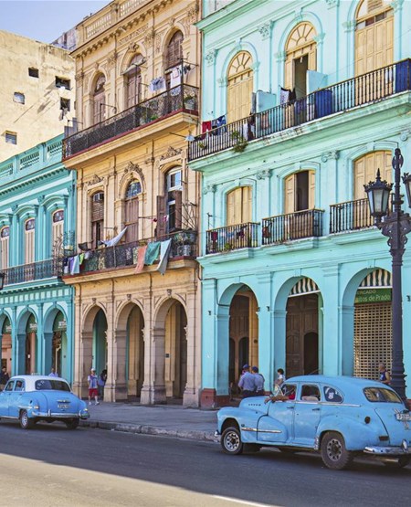 Farverige husfacader og amerikanerbil i Havana på Cuba