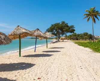 Flot sandstrand med parasoller i Trinidad på Cuba