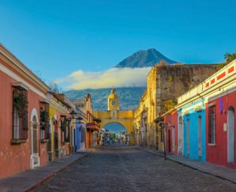Gammel og farverig gade i UNESCO-fredede Antigua i Guatemala med vulkan i baggrunden