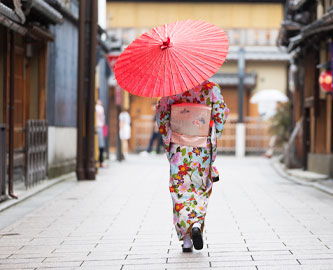 Geisha med paraply og kimono i Japan