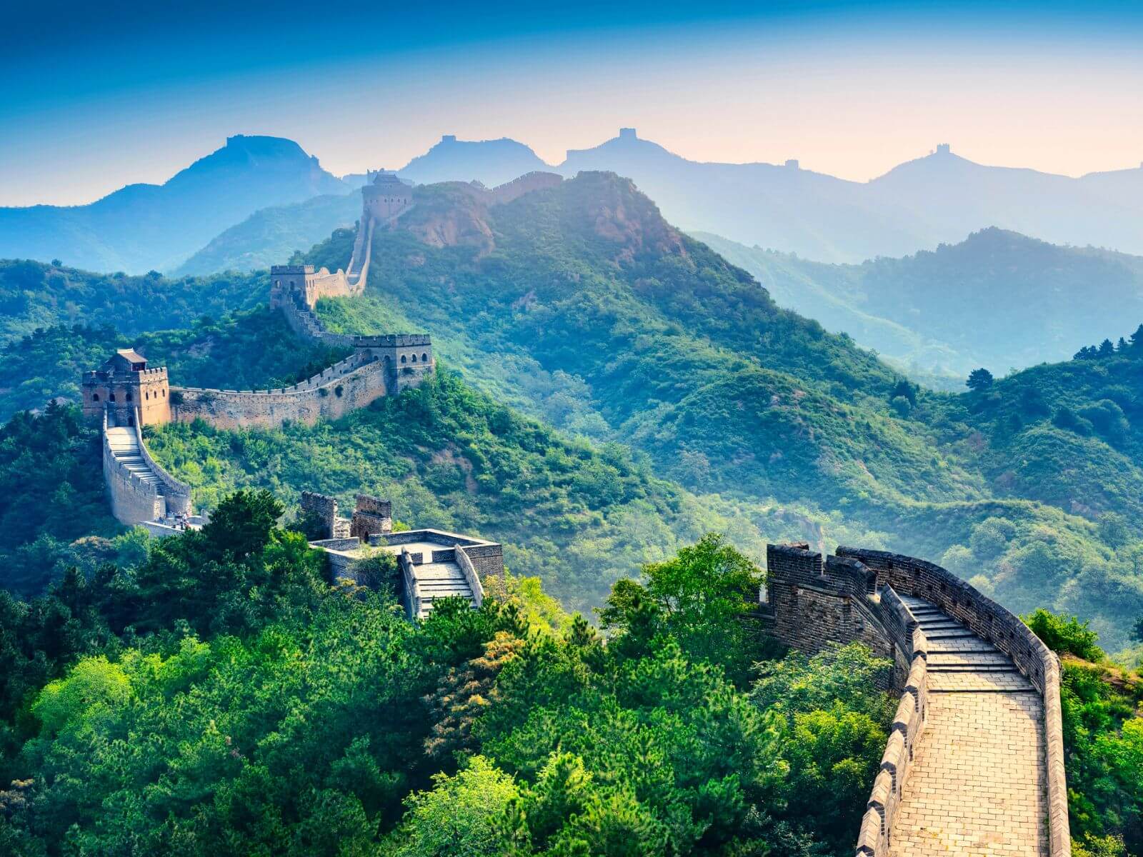Den Kinesiske Mur, der snor sig gennem det frodige, bjergrige landskab i Kina