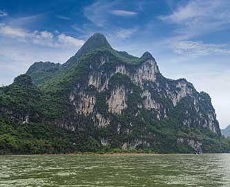 Udsigt til båd på vand foran Nine Horses Mountain i Kina