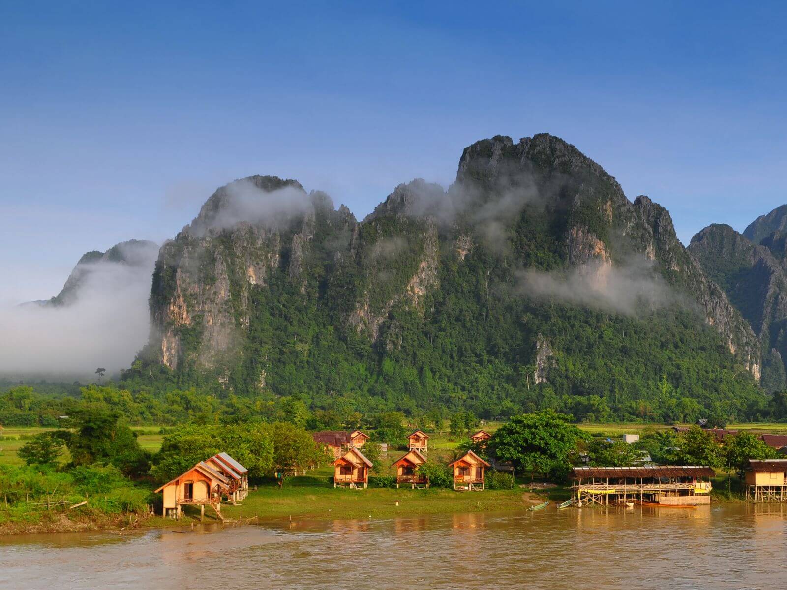 Huse og bjerge langs Mekong-floden nær Vang Vieng, Laos Huse og bjerge langs Mekong-floden nær Vang Vieng, Laos