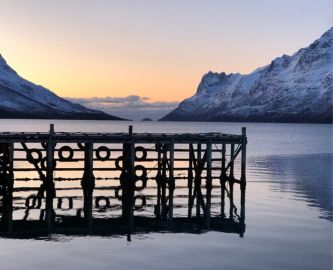 Bådbro i Tromsø i tusmærke med udsigt til snedækkede fjelde
