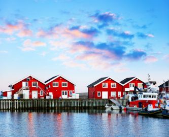 Bodø Havn med røde fiskerhuse og flot blå himmel