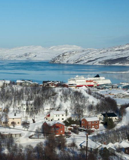 Udsigt over Kirkenes med by, fjord, krydstogtskib og snedækkede fjelde