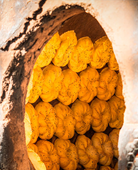 Traditionel usbekisk brødbagning i tandoor-ovn Traditionel usbekisk brødbagning i tandoor-ovn