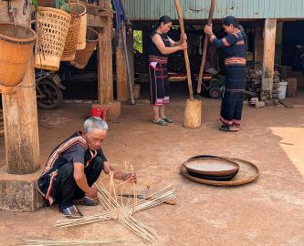 Vietnamesisk landsby, hvor mand i forgrund producerer kurveflet, Vietnam