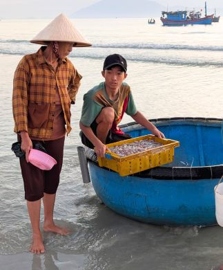 Vietnamesiske fiskere i runde både på stranden i Ninh Thuy, Vietnam