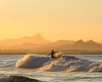Surfer på stor bølge i Byron Bay i Australien