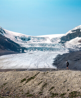 Mand i vandretøj nyder udsigten over Athabasca-gletscheren i Canada