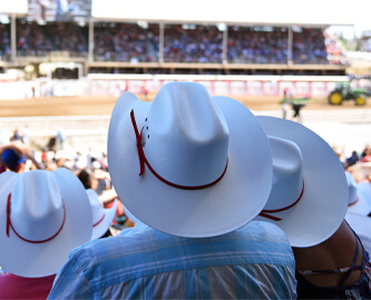 Tilskuer med hvid cowboyhat ved Calgary Stampede