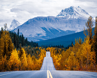 Kørselsudsigt af vej med bjerge i baggrunden i Icefields Parks, Canada