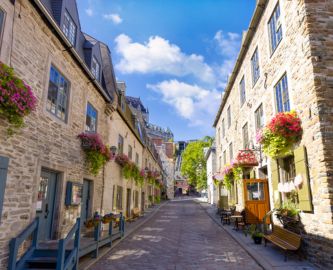 Gade i Old Québec med blomsterkasser og brostensbelagte veje