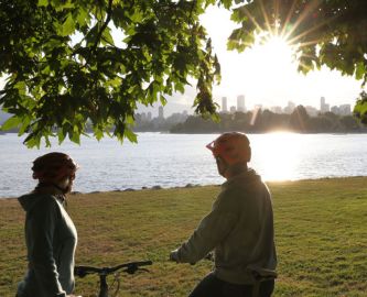 Cyklister nyder udsigten over vandet og Vancouver