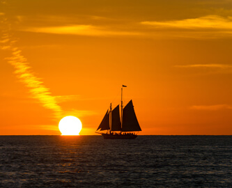 Solnedgang over havet med skib i Florida