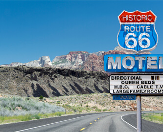 Route 66 Motel skilte ved vej med udsigt til bjerge i baggrunden