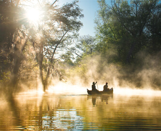 Flot udsigt til to personer i en kano i solskin i Sydstaterne