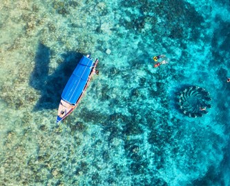 Båd ude på vandet med revet nedenunder på Gili-øerne, Bali