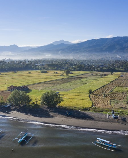 Smuk udsigt over strand og landskab med bjerge i Lovina på Bali