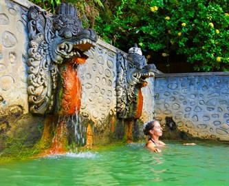 Kvinde der bader i Lovinas varme kilder på Bali