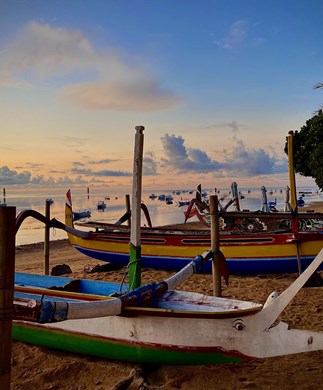 Udsigt over strand med både i solnedgang på Sanur, Bali