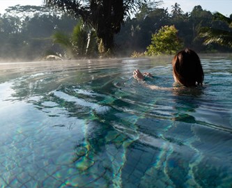 Kvinde der slapper af i poolen ved Sidemen på Bali