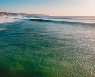 Surfere på havet ved Uluwatu på Bali