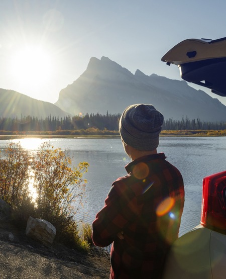 Mand på bilferie, kigger ud over Banff National Park, Canada