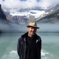 Rejseleder Peter Porskjær foran smuk sø og sneklædte bjerge i Canada
