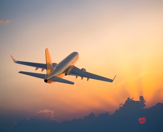 Smuk udsigt af fly oppe i skyerne i solnedgang