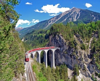 Bernina Expressen kører over viadukt i Alperne, Schweiz Bernina Expressen kører over viadukt i Alperne, Schweiz
