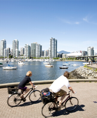 Cyklister i Toronto med bygninger i baggrunden og blå himmel