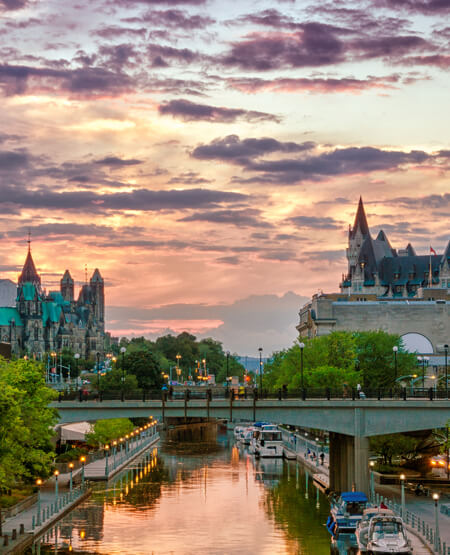 Smuk udsigt over flod og bygninger i Ottawa i aftenslys