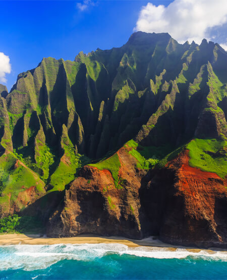 Smuk kyst med strand og bjerge ved Hawaii